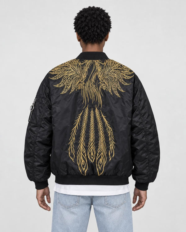Model wearing the black bomber jacket with gold wing embroidery and light-wash jeans, back view
