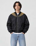 Model wearing the black bomber jacket zipped up over a white tee, front view