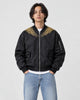 Model wearing the black bomber jacket zipped up over a white tee, front view
