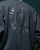 Close-up of the circular CREATE THE FUTURE, EH, MIRACULOUS print on the back of the dark jacket