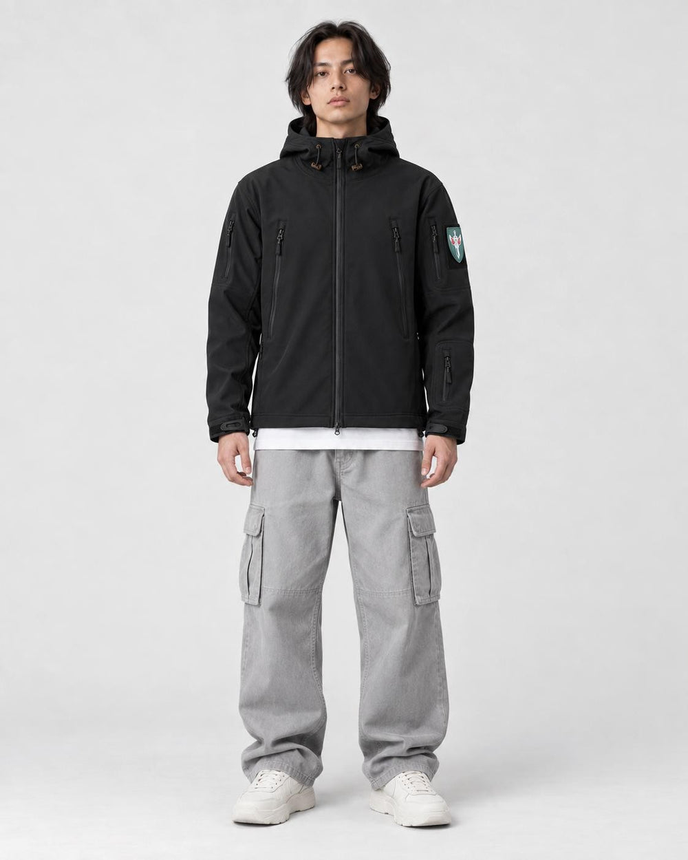Model wearing the black softshell hooded jacket with gray cargo pants, front view