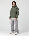 Model wearing the army green softshell jacket, three-quarter view