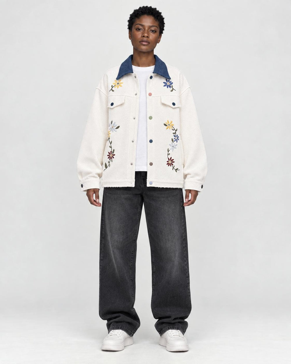 Model wearing the cream floral embroidered jacket with a denim-blue collar, front view