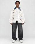 Model wearing the cream floral embroidered jacket with a denim-blue collar, front view