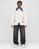 Model wearing the cream floral embroidered jacket with a denim-blue collar, front view