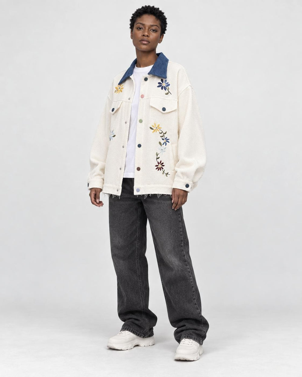 Model wearing the cream floral jacket over a white tee, three-quarter view