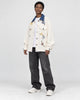 Model wearing the cream floral jacket over a white tee, three-quarter view