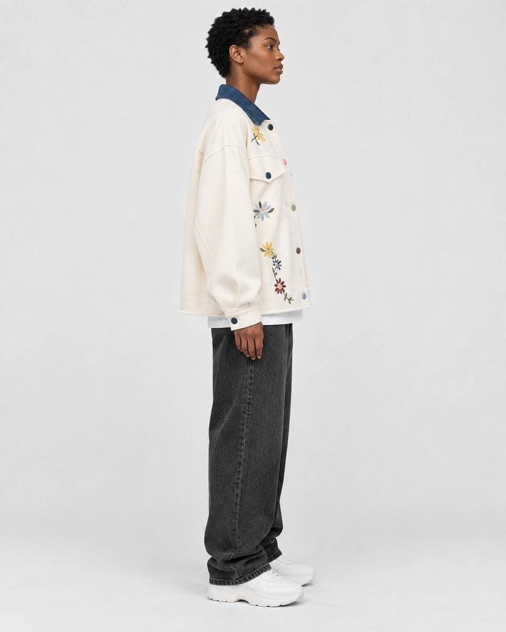 Model wearing the cream floral embroidered jacket, side view