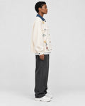 Model wearing the cream floral embroidered jacket, side view