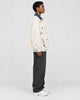 Model wearing the cream floral embroidered jacket, side view