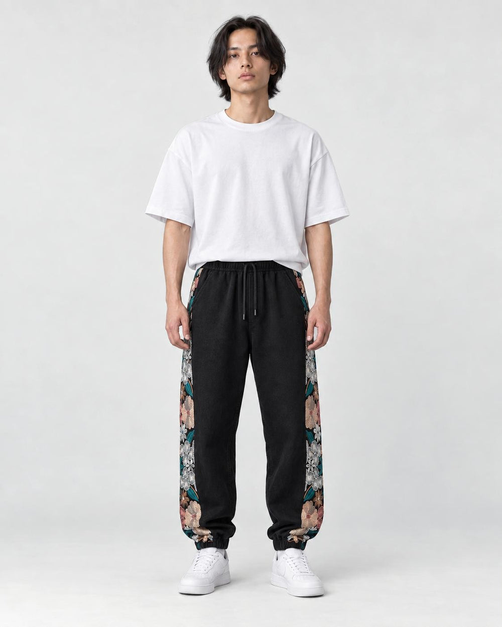 Model wearing the black floral embroidered jogger pants, front view