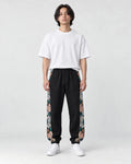 Model wearing the black floral embroidered jogger pants, front view