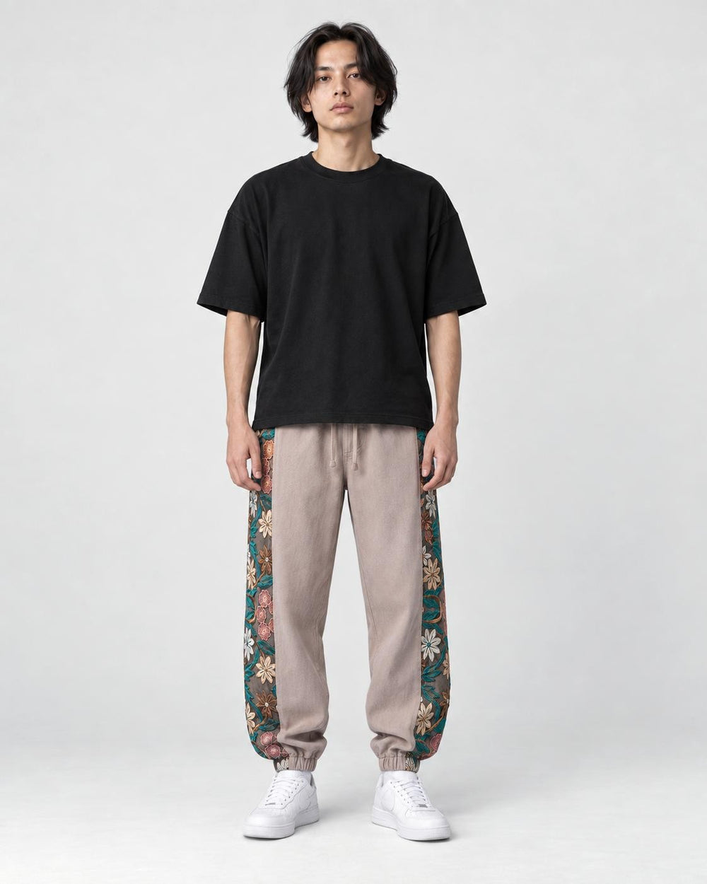 Model wearing the dusty pink floral embroidered jogger pants, front view