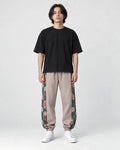 Model wearing the dusty pink floral embroidered jogger pants, front view