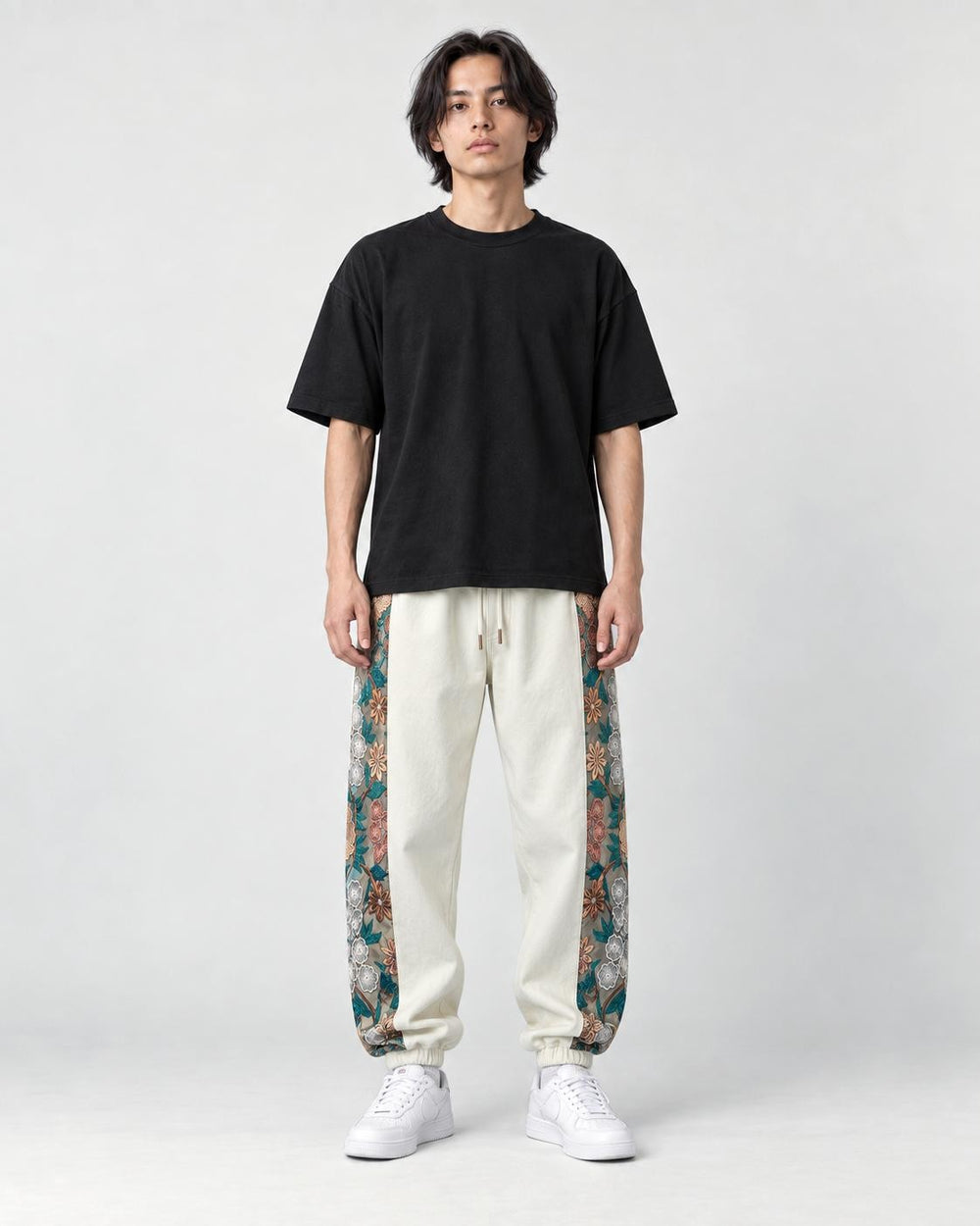 Model wearing the off-white floral embroidered jogger pants, front view