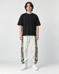 Model wearing the off-white floral embroidered jogger pants, front view
