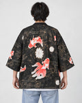 Model wearing the black goldfish and fireworks haori cardigan seen from behind over a white tee and light-wash jeans
