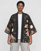Model wearing the black goldfish and fireworks haori cardigan open over a white tee and stone trousers, front view