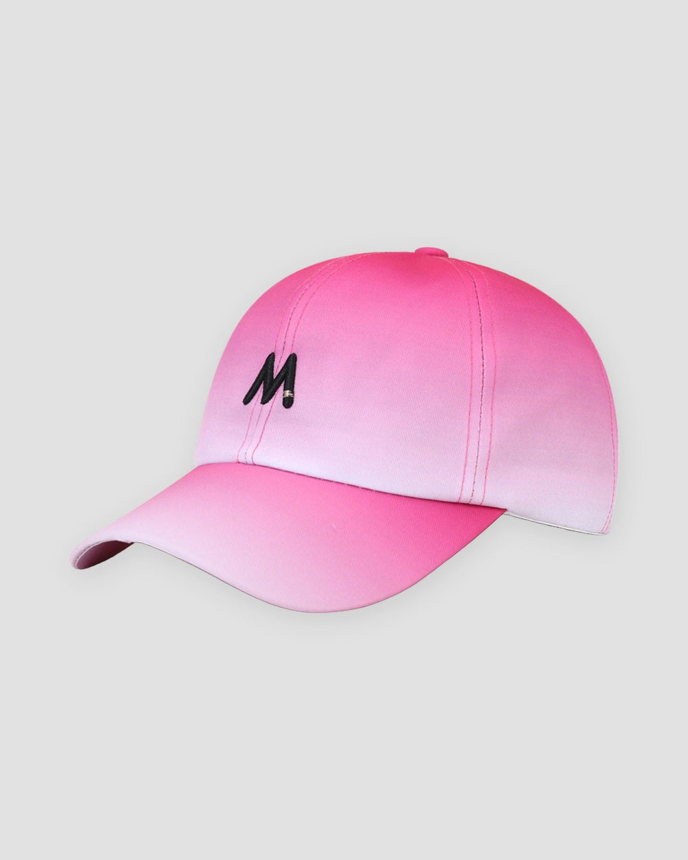 Baseball cap fading from hot pink at the crown to white at the brim, with a black M on the front