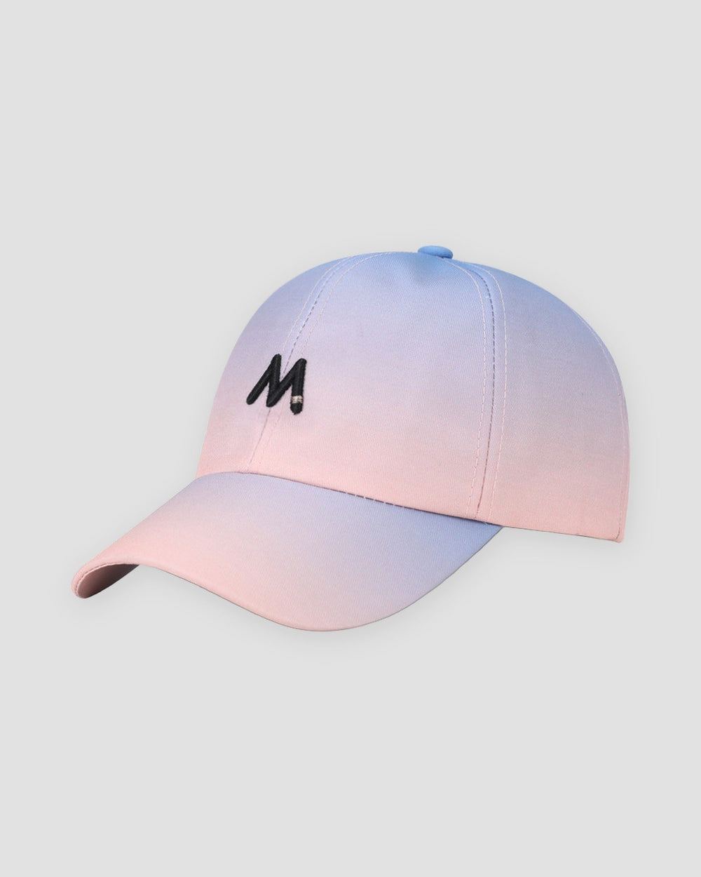 Baseball cap fading from lilac at the crown to peach pink at the brim, with a black M on the front