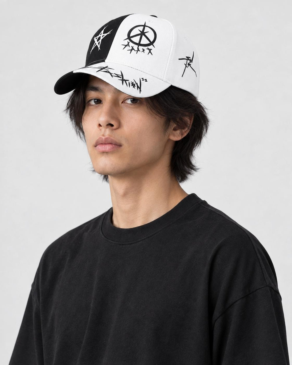 Model wearing the black and white graffiti cap, three-quarter view