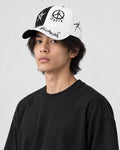 Model wearing the black and white graffiti cap, three-quarter view