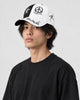Model wearing the black and white graffiti cap, three-quarter view