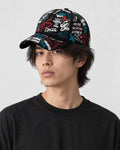 Model wearing the black graffiti print cap, three-quarter view
