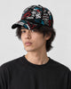 Model wearing the black graffiti print cap, three-quarter view