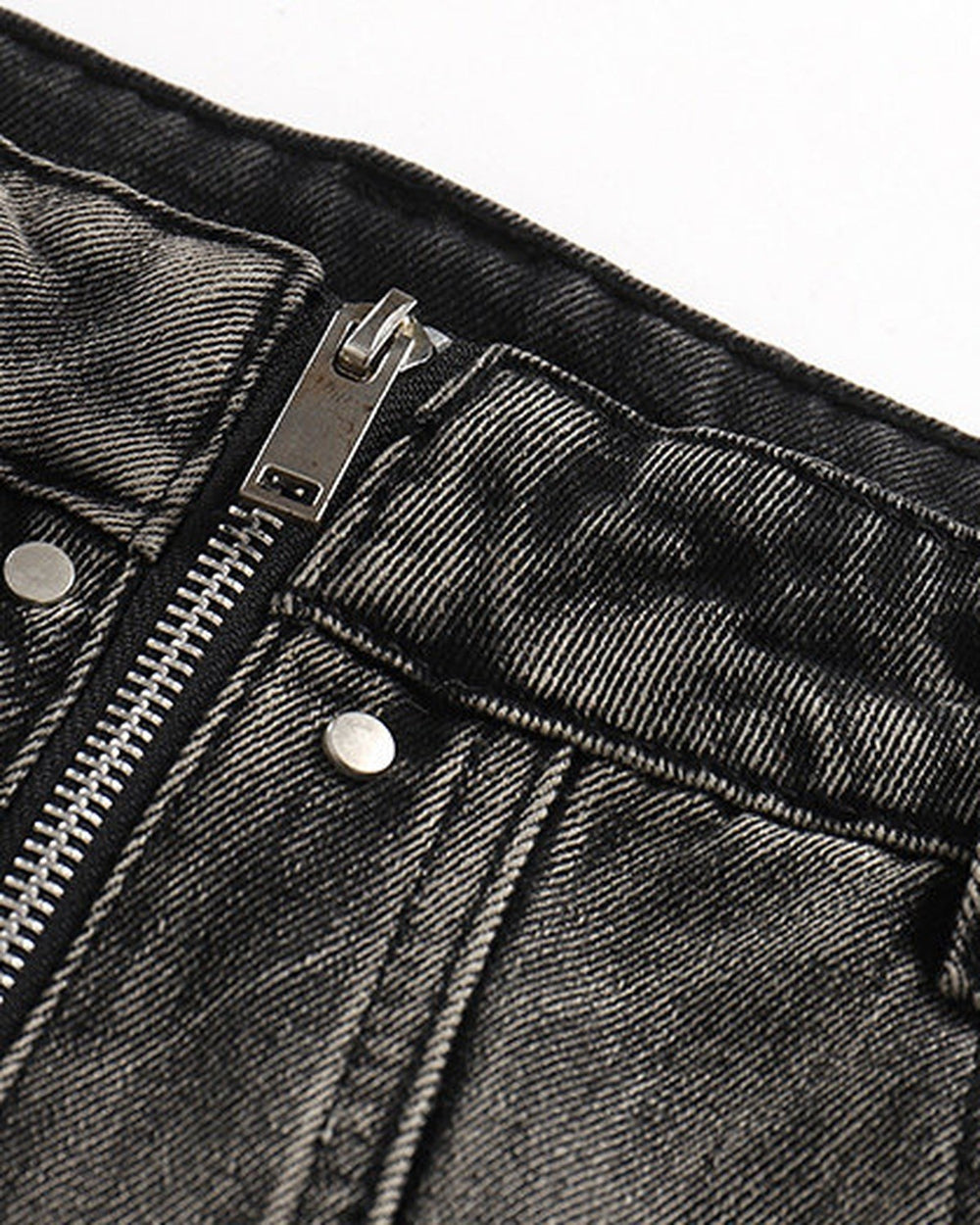 Close-up of the waistband, exposed zip fly and washed denim