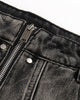 Close-up of the waistband, exposed zip fly and washed denim