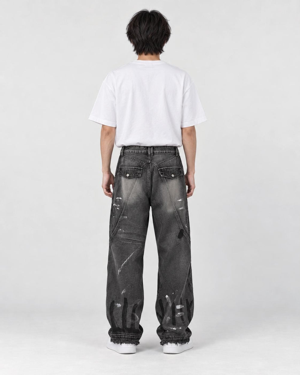 Model wearing the graffiti jeans, back view with flap pockets and painted letters