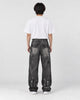 Model wearing the graffiti jeans, back view with flap pockets and painted letters