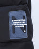 Close-up of the felt N badge on the upper sleeve of the black puffer jacket