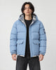 Model wearing the light blue puffer jacket with camouflage lining over a black tee, front view