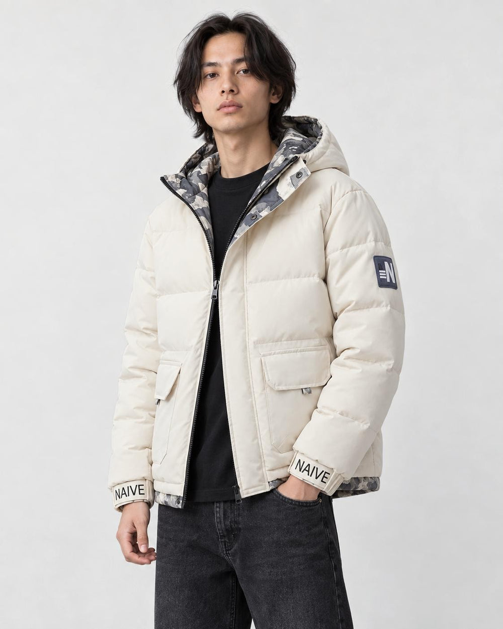Model wearing the cream puffer jacket with camouflage lining, three-quarter view