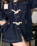 Close-up of the cream cord-and-wood toggles, metal buttons and flap pockets on the dark indigo denim jacket