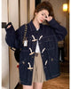Dark indigo horn toggle denim jacket with cream toggles, flap pockets and metal buttons, worn with a beige skirt