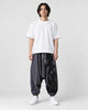 Model wearing the dark gray ink splash harem pants with a white tee, front view