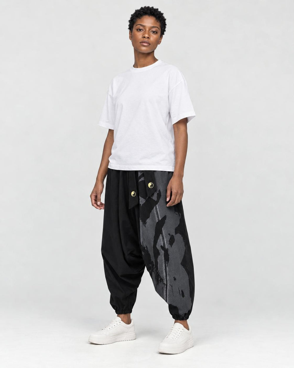 Model wearing the black ink splash harem pants, three-quarter view