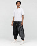 Model wearing the black ink splash harem pants, three-quarter view