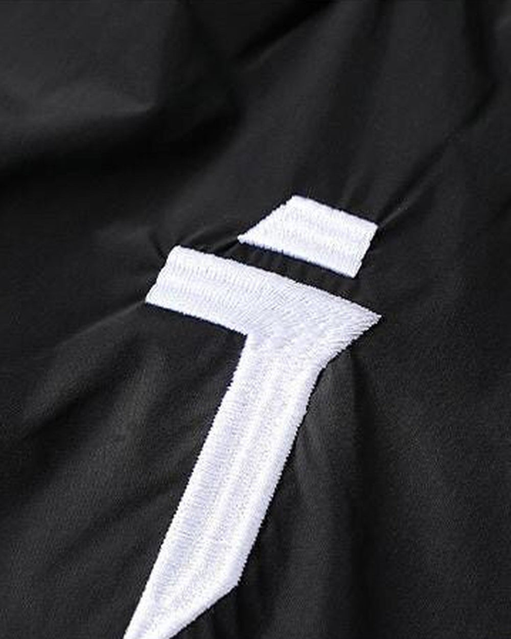 Close-up of the embroidered white logo on the front thigh