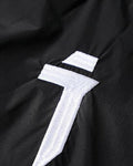 Close-up of the embroidered white logo on the front thigh