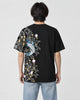 Man seen from behind in the black T-shirt with a koi, waves and plum blossoms down the left side of the back