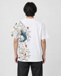 Man seen from behind in the white T-shirt with a koi, waves and plum blossoms down the left side of the back