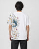 Man seen from behind in the white T-shirt with a koi, waves and plum blossoms down the left side of the back