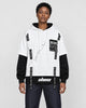 Model wearing the white layered hoodie with dark jeans, front view