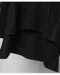 Close-up of the layered hem and the longer cape panel on the black hoodie