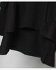 Close-up of the layered hem and the longer cape panel on the black hoodie