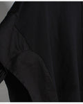 Close-up of the cargo-pocket panel layered over the sleeve of the black hoodie